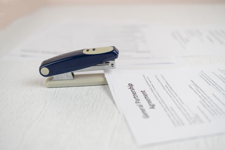 a stapler and the documents files in office on the table, staple the paper sheets of resume and contracts