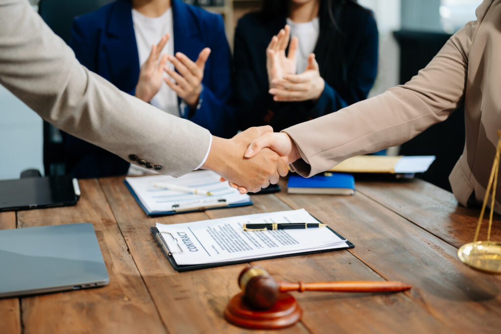Business and lawyers discussing contract papers with brass scale