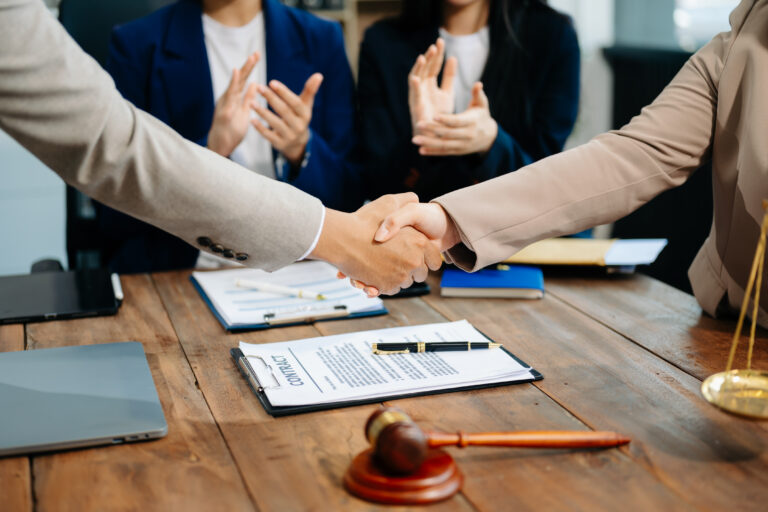 Business and lawyers discussing contract papers with brass scale