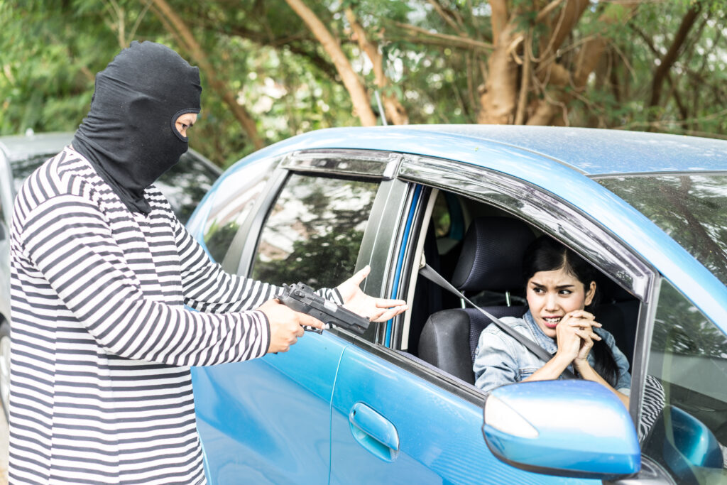 Robber pointing a gun to scare young woman and try to rob her ca